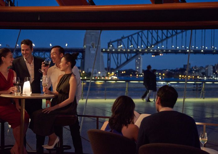 Couple enjoying an evening out with friends at Bennelong Restaurant, Sydney Opera House