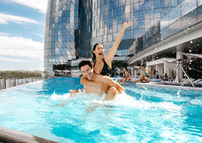 Couple enjoying the luxurious pool at Crown Towers hotel, Crown Sydney, Barangaroo