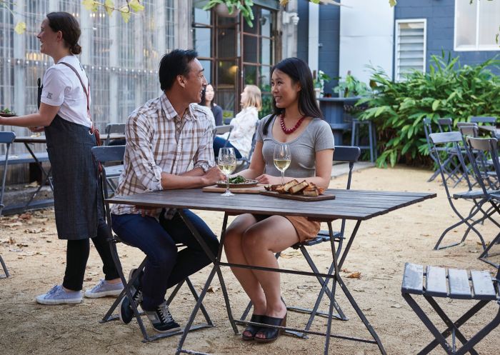 Couple sitting outdoors at Three Blue Ducks, Rosebery 