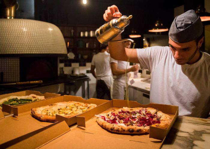 Chef preparing pizza at Gigi's Pizzeria, Newtown