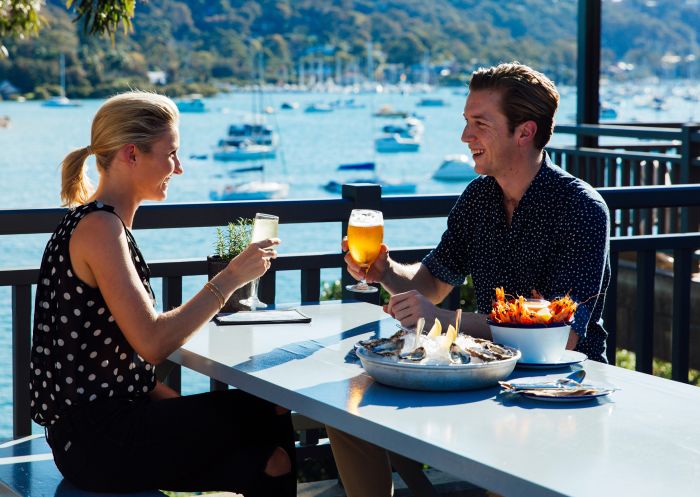 Couple enjoying food and wine with views of Pittwater at Newport Arms Hotel, Newport