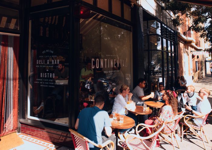 People dining outdoors at Continental Deli, Newtown