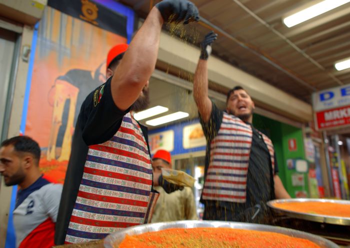 Cooks preparing knafeh at Yummy Yummy Knafeh's stall at Lakemba Nights during Ramadan