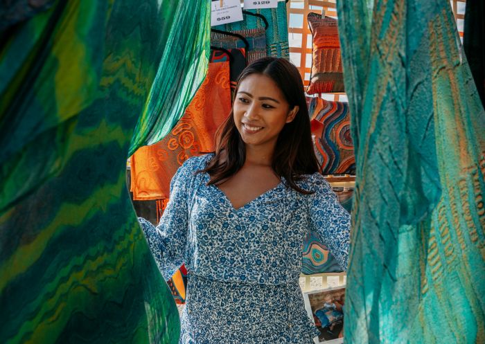 Woman explores the Aboriginal artwork for sale at the Saretta Art and Design stand Blak Markets at Bare Island, La Perouse