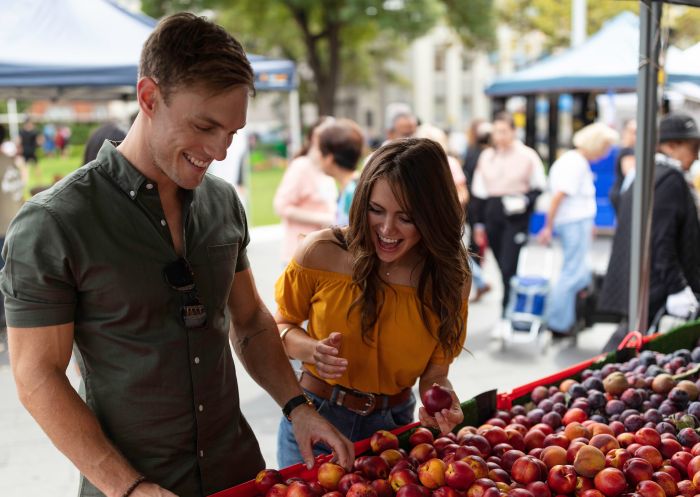 Couple browsing for fresh fruit at the Farmers Market in Centenary Square, Parramatta