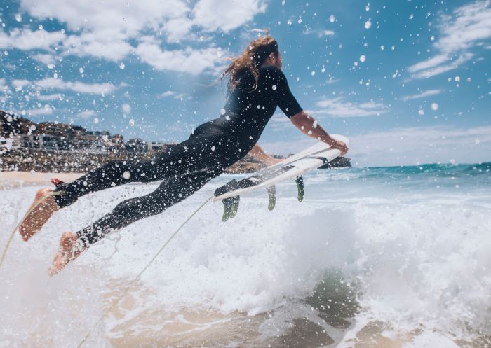 Surfer heading out to catch a wave at Bronte Beach, Sydney