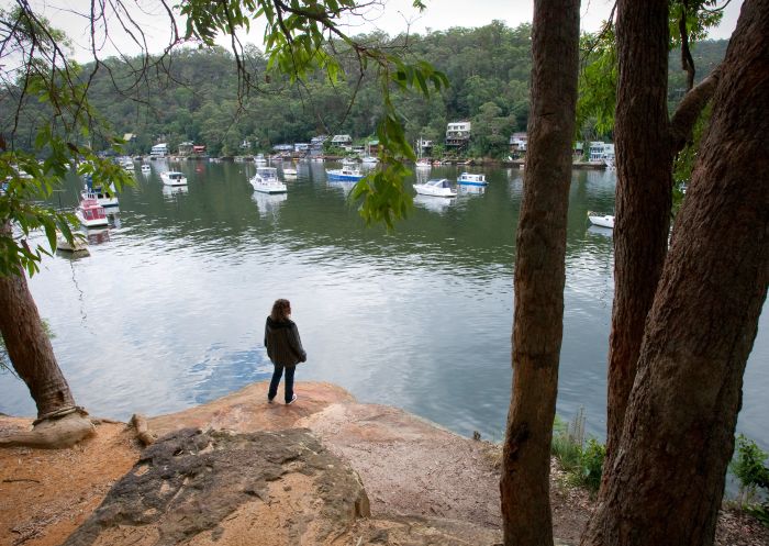 A female tourist enjoys the view of the Berowra Creek from the Benowie Walking Track in Berowra Valley National Park, Berowra 
