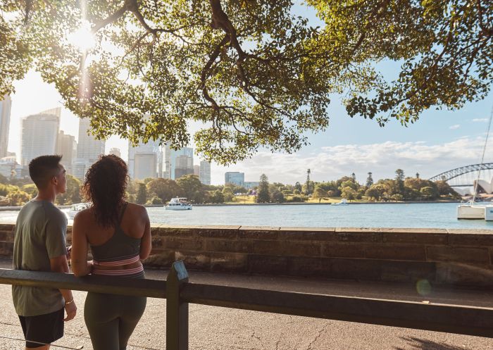 Friends enjoying a run through the Royal Botanic Gardens overlooking the Harbour Bridge and Opera House, Sydney