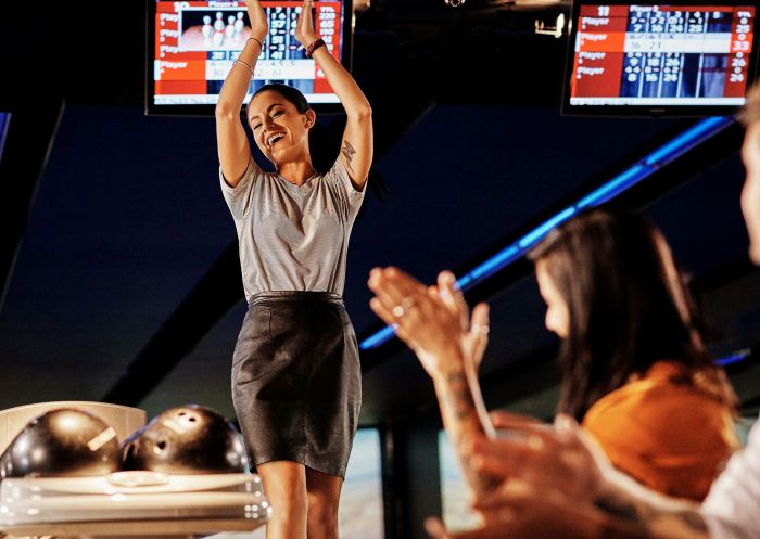 Woman clapping after a strike at Strike Bowling Chatswood, Chatswood
