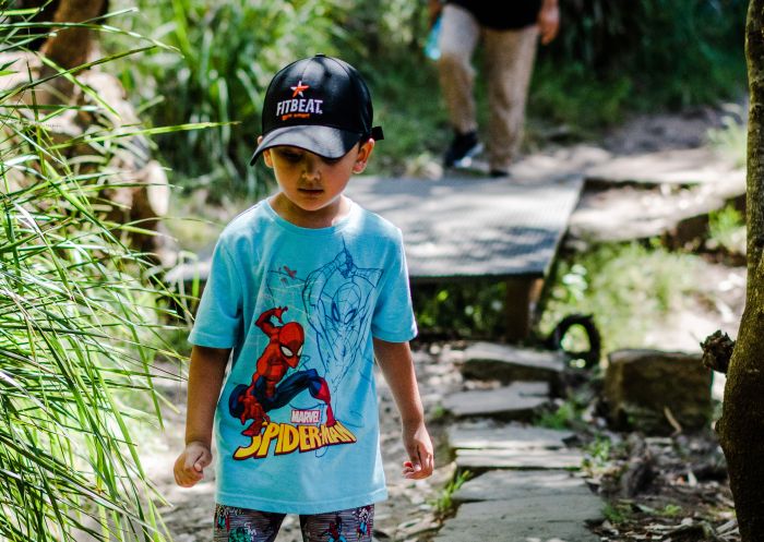 Boy walking through Arrunga Bardo Walk at Lake Parramatta Reserve, Parramatta