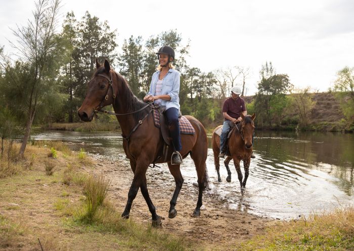 Couple enjoying a horseriding experience along the Hawkesbury River with Hawkesbury Valley Equestrian Centre, Yarramundi