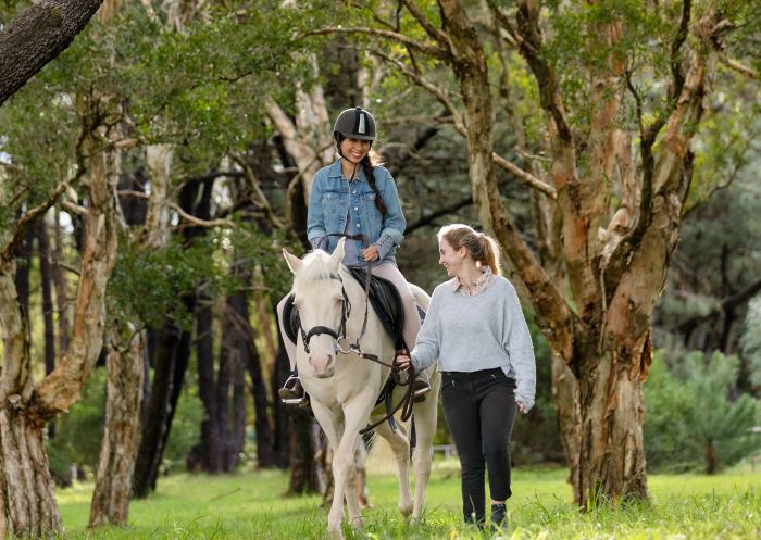 Woman enjoying a horse riding experience with Eastside Riding Academy in Centennial Park, Sydney