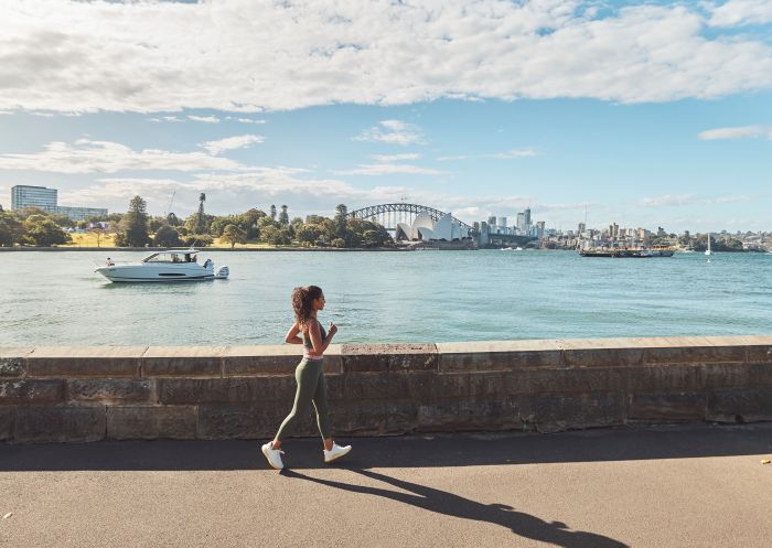 Woman running along the foreshore through the Royal Botanic Gardens, Sydney