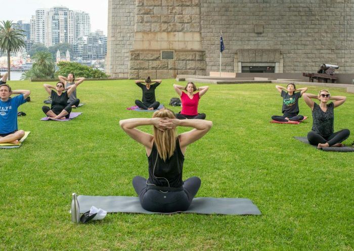 Group of people enjoying yoga class with Yoga Under the Bridge, Dawes Point