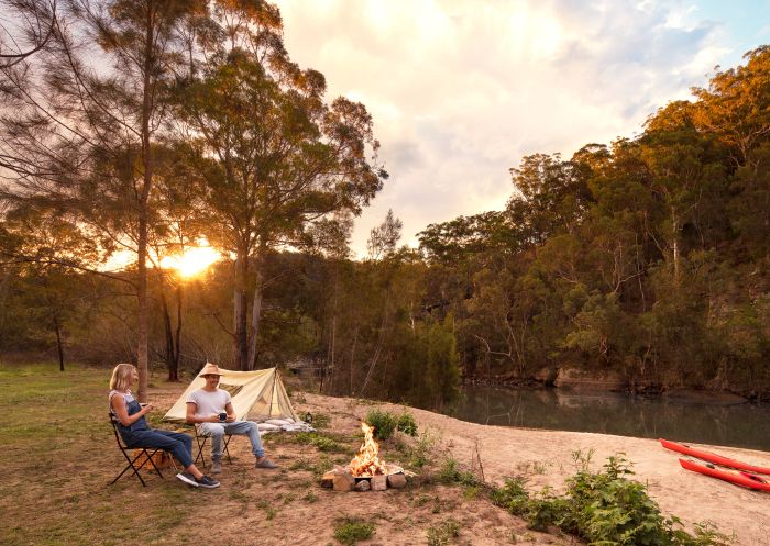 Camping, Hawkesbury River Couple enjoying a campfire by their tent on the Hawkesbury River, Lower MacDonald