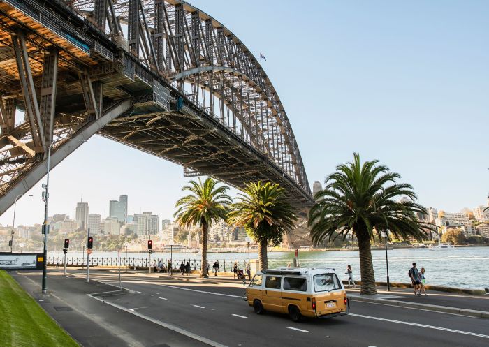 Sydney Harbour Bridge, Sydney A yellow campervan driving along Hickson Road under the Sydney Harbour Bridge, Sydney