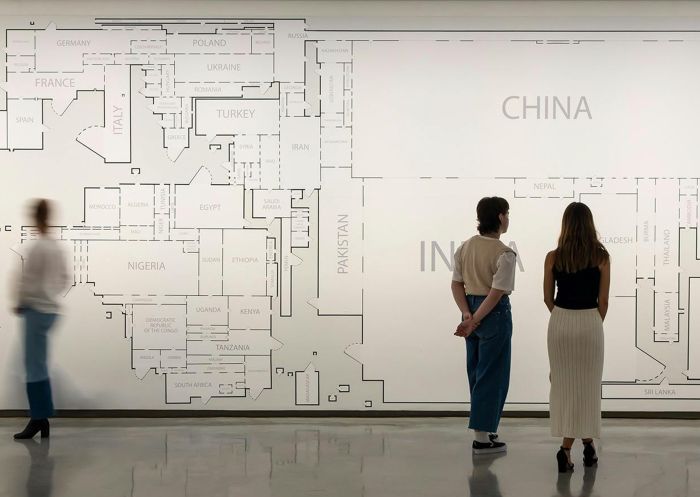 Three people viewing Louisa Burardeci's wall installation at the Museum of Contemporary Art 