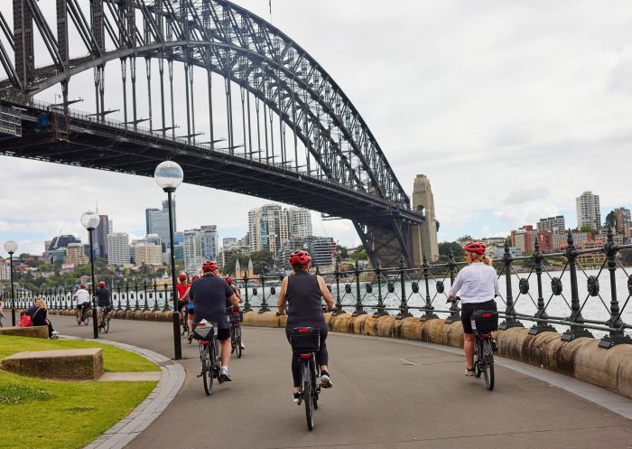 People riding bikes past Hickson Road Reserve with Sydney Harbour Bike Tours, The Rocks