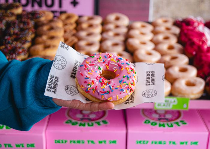 Grumpy Donuts, Camperdown - Credit: Grumpy Donuts Holding a pink glazed donut, Grumpy Donuts, Camperdown - Credit: Grumpy Donuts