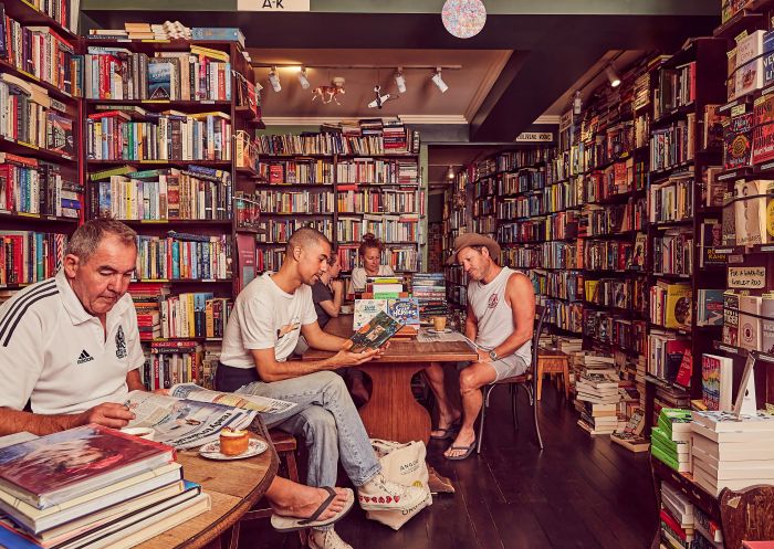 ガートルード&アリス・カフェ書店、ボンダイ- クレジット: ガートルード&アリス・カフェ書店 ガートルード&アリス・カフェ書店(ボンダイ)の店内で読書をする人々 - 提供:ガートルード&アリス・カフェ書店