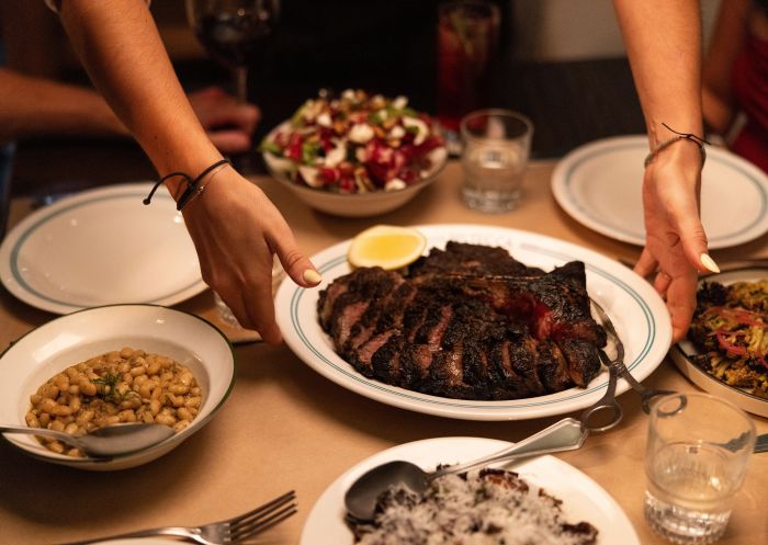 Friends enjoy a delicious meal with wine, Bistecca Restaurant, Sydney