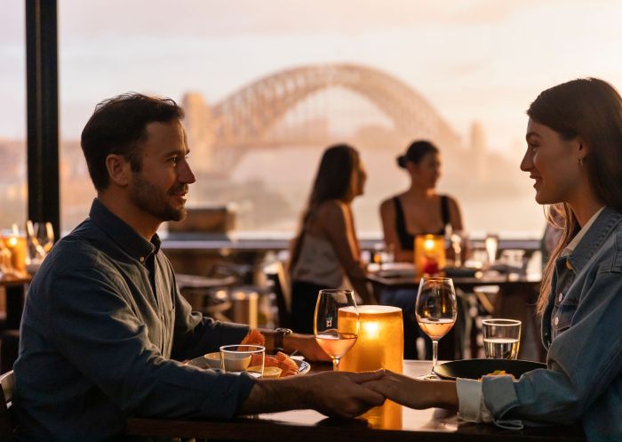 Couple enjoying food and drink with views across Sydney Harbour, Cafe Sydney, Sydney