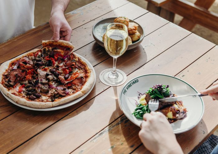A table of two people eating a dish and pizza, Tommy's Cafe, Vineyard - Credit: Tommy's Cafe