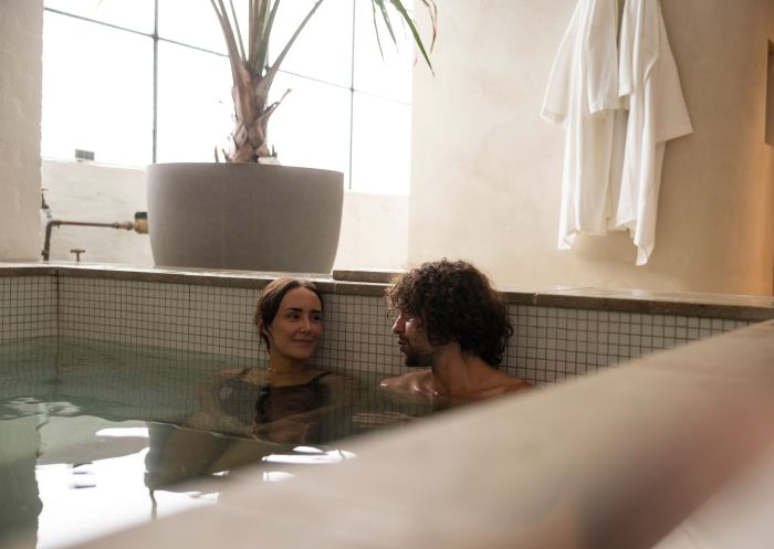 Couple relaxes in the pool at Capybara Bathhouse, Surry Hills