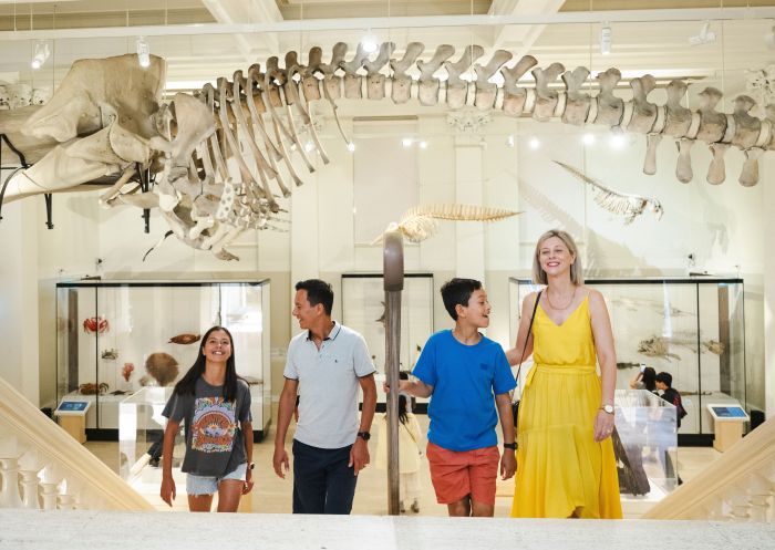 Family visiting with dinosaur bones in background, Australian Museum, Sydney