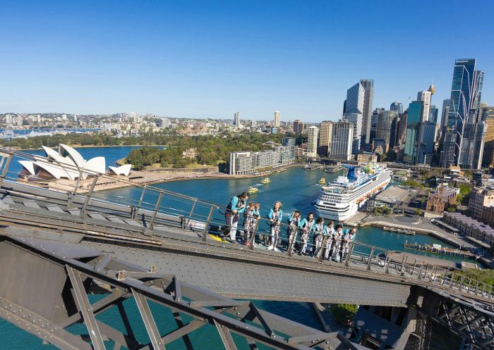 A tour group walking up the upper arch of the Sydney Harbour Bridge with the Harbour behind, The Rocks - Credit: BridgeClimb Sydney