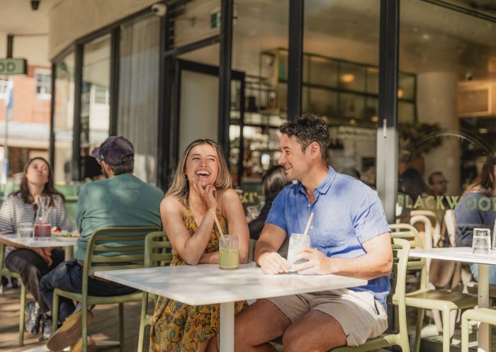 Couple having a drink outdoors, Blackwood Cafe, Bondi 