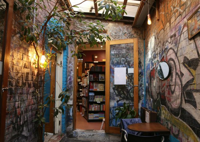 Side passage into the bookstore, colourful graffiti covering the walls, Sappho Books, Cafe and Bar, Glebe - Credit: Sappho Books