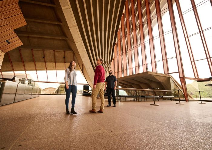 Tour guide with a man and a woman looking up at the cathedral ceiling of the Concert Hall, Sydney Opera House Tours, Sydney CBD - Credit: Sydney Opera House