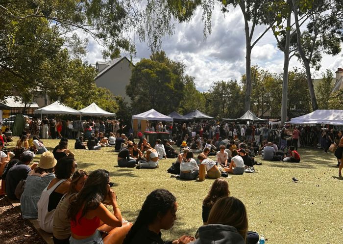 People sitting in a grassy area next to market stalls at Glebe Markets, Glebe - Credit: Glebe Markets