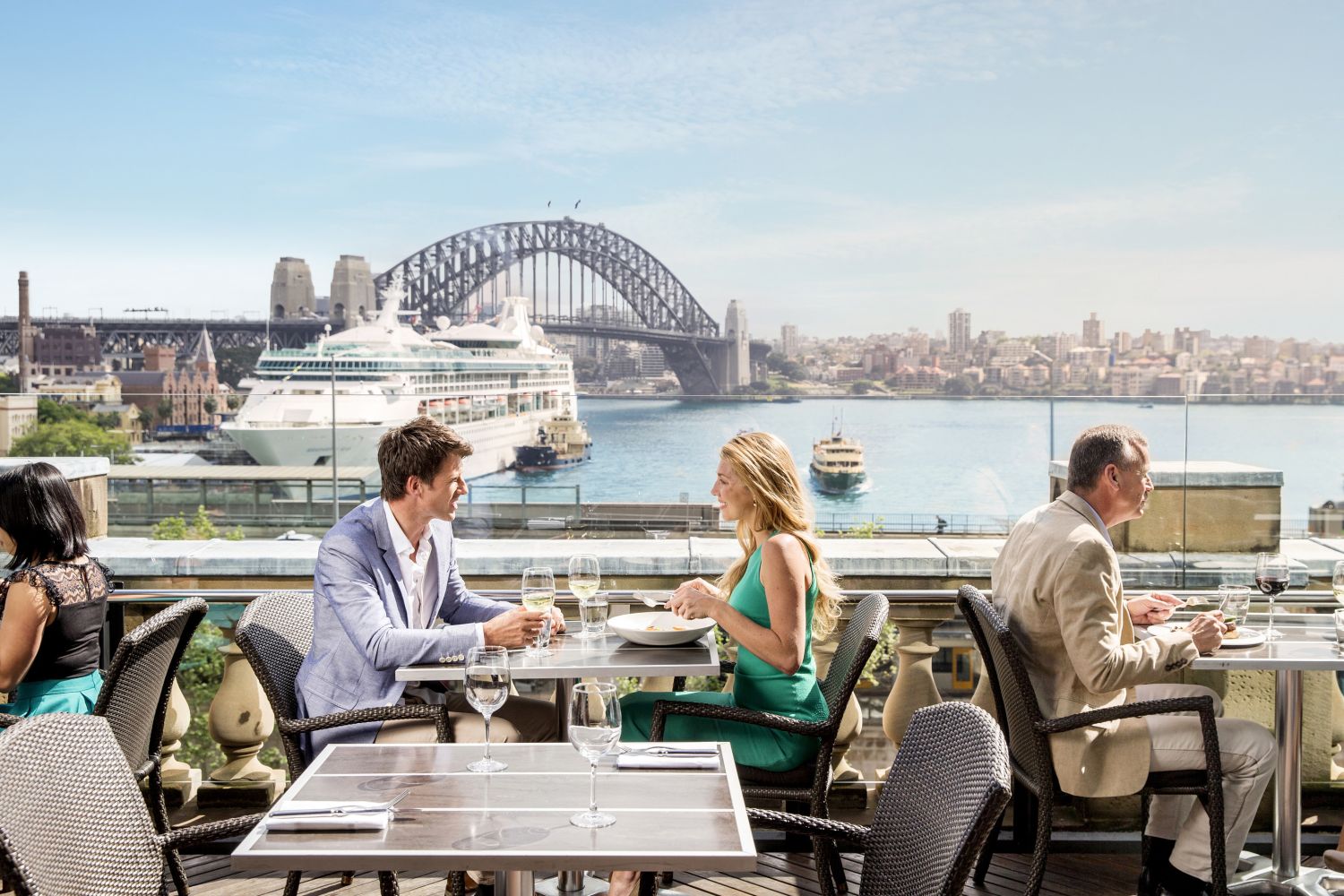 Couple enjoying a lunch with views of a cruise ship at Cafe Sydney on the rooftop of Customs House, Circular Quay
