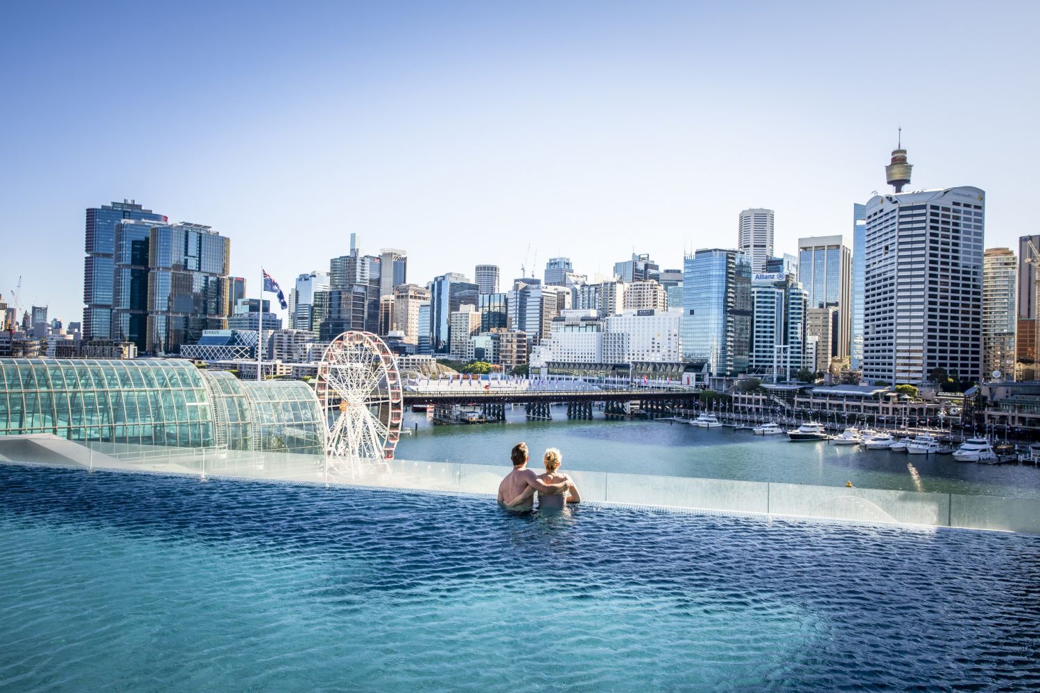 Couple enjoying Sofitel Sydney's rooftop pool with views across Darling Harbour