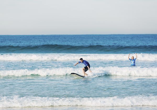 Man catches his first wave with Let's Go Surfing instructor at Bondi Beach in Bondi