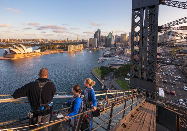 Friends enjoying a twilight BridgeClimb Sydney experience overlooking Sydney Harbour