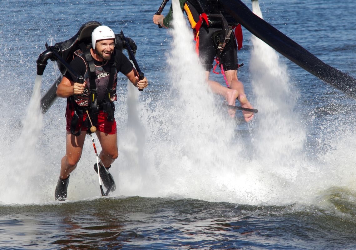 Jetpack Adventures, Penrith A jetpack-strapped man flying out of the water, Sydney International Regatta Centre