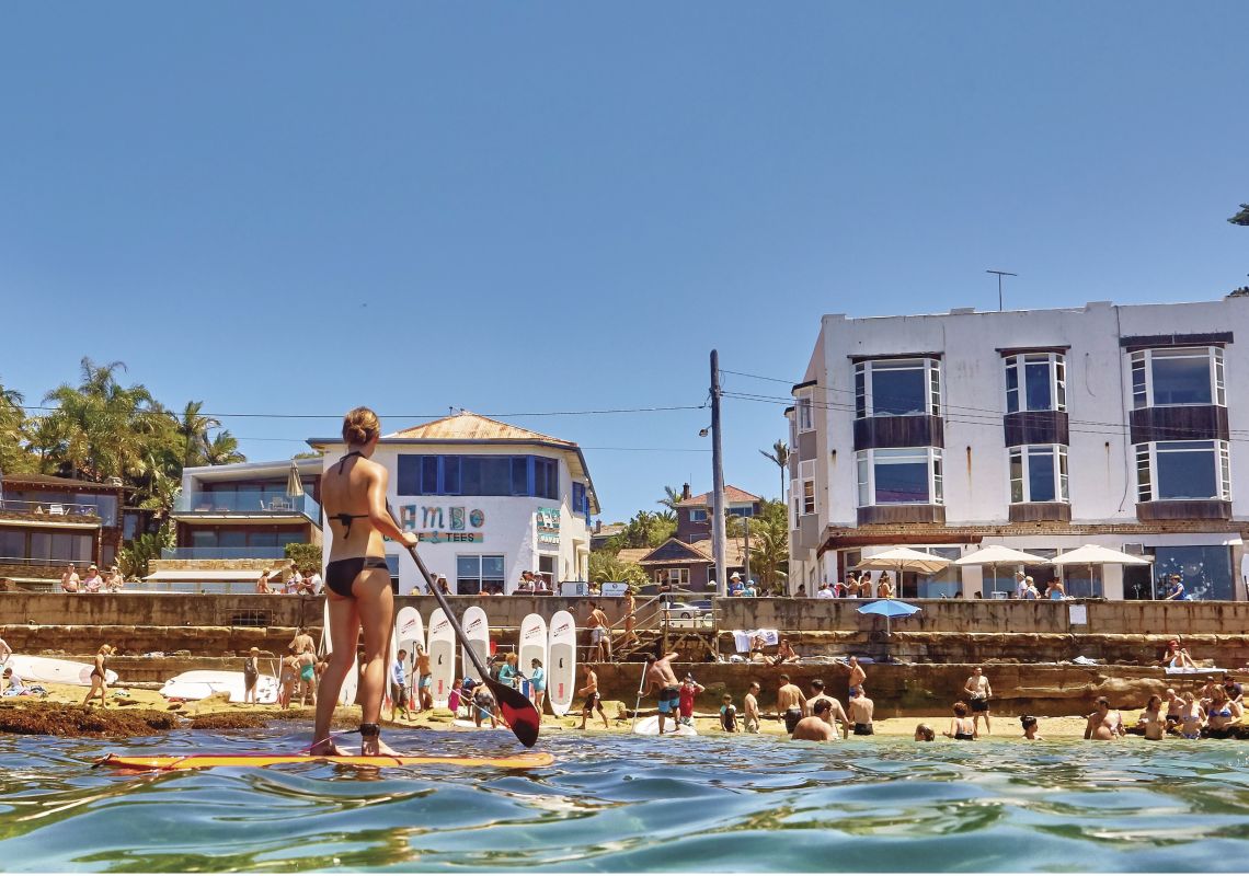 Views of beachgoers and a stand up paddleboarder at Cabbage Tree Bay Aquatic Reserve in Manly Cabbage Tree Bay Aquatic Reserve, Manly