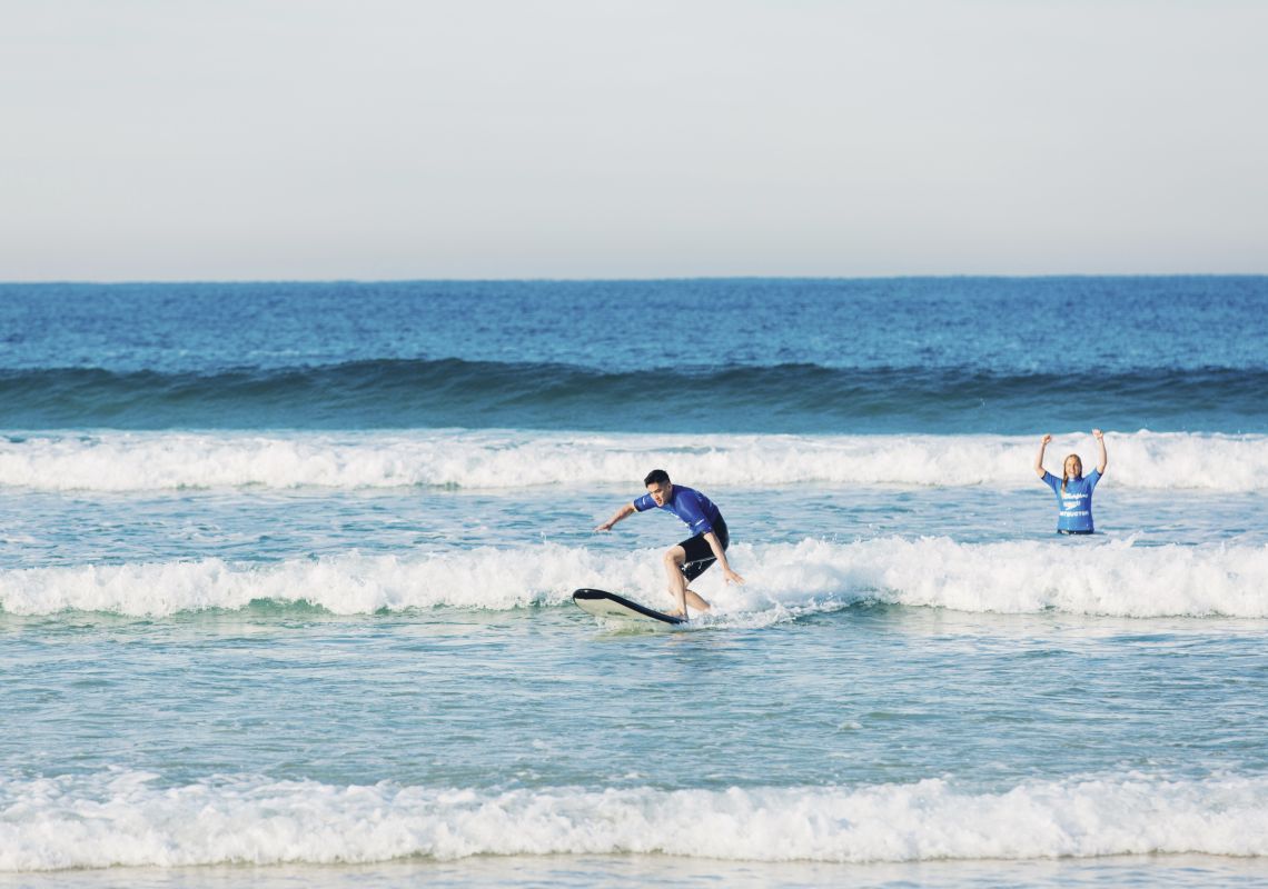 Man catches his first wave with Let's Go Surfing instructor at Bondi Beach in Bondi Let's Go Surfing, Bondi Beach
