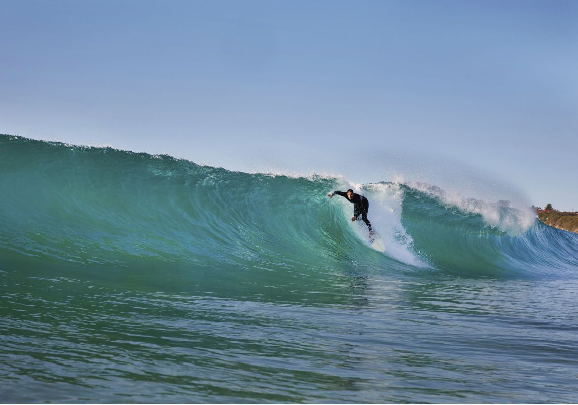 Surfer catches a wave at Mona Vale Beach Surfing at Mona Vale