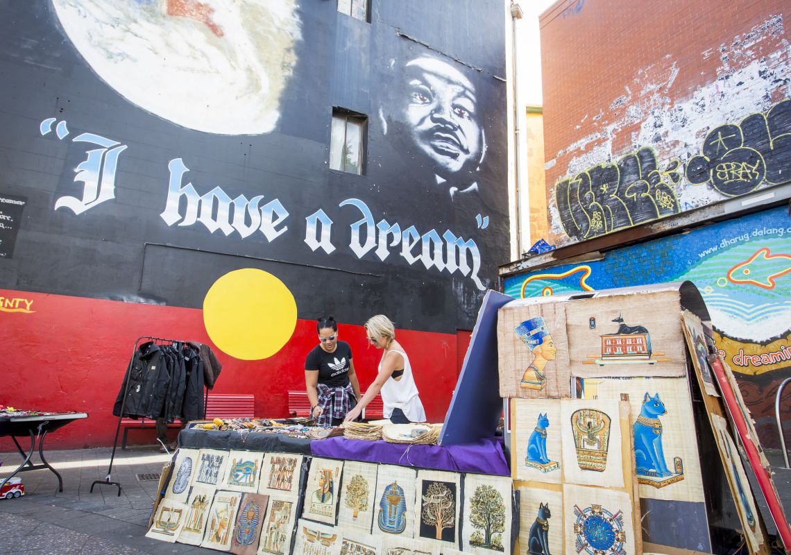 Martin Luther King mural on King Street, Newtown Women browsing through art on sale besides Martin Luther King mural on King Street, Newtown