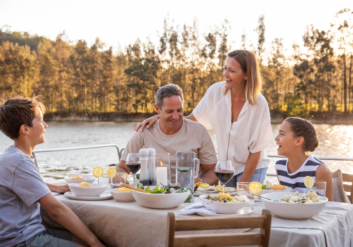Family on houseboat, Hawkesbury River Family relaxing over a meal aboard a houseboat, Hawkesbury River