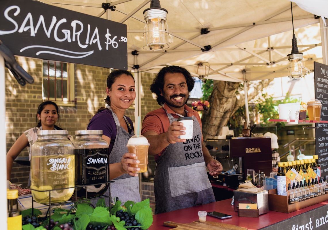 Stall owners with beverages at Friday Foodie Market in The Rocks, Sydney City