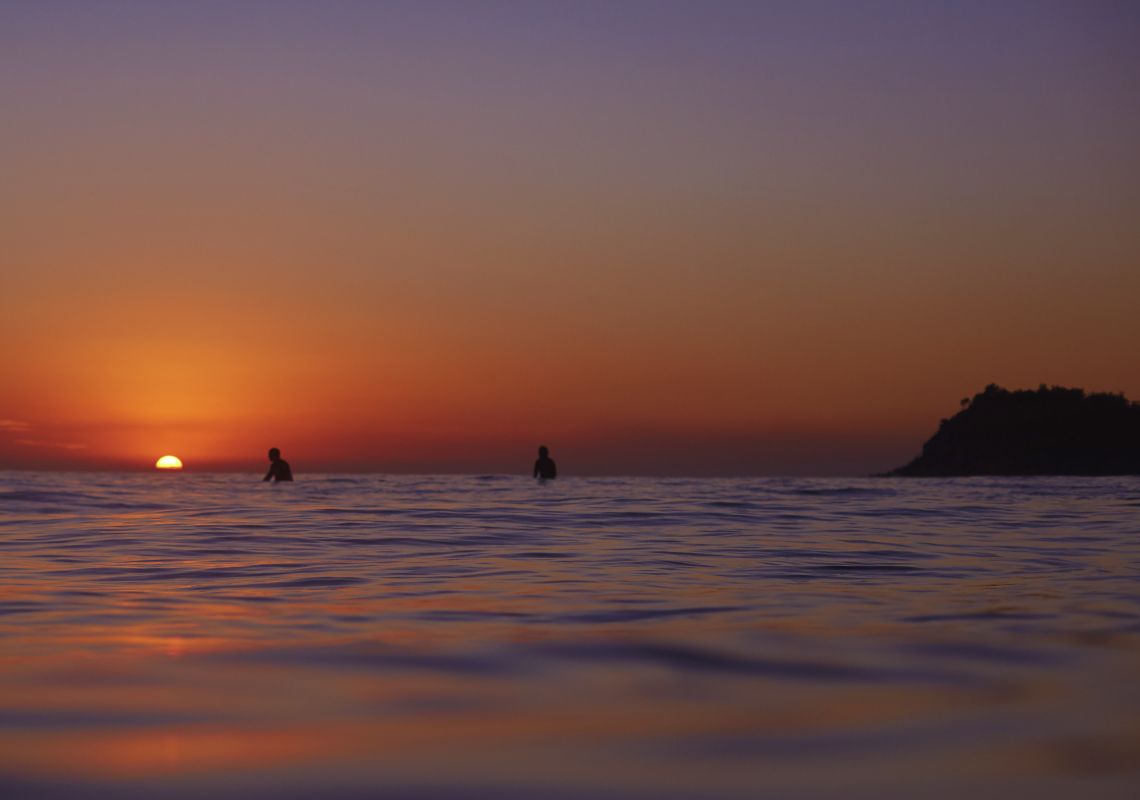 Surfing at Manly Surfers catching a morning wave at sunrise at Manly Beach