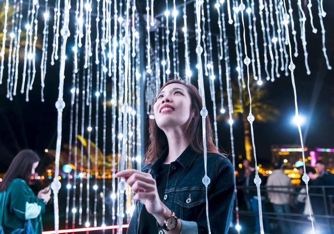 Vivid Sydney 2019 Woman enjoying the Let It Snow light installation in Hickson Road Reserve, The Rocks during Vivid Sydney 2019