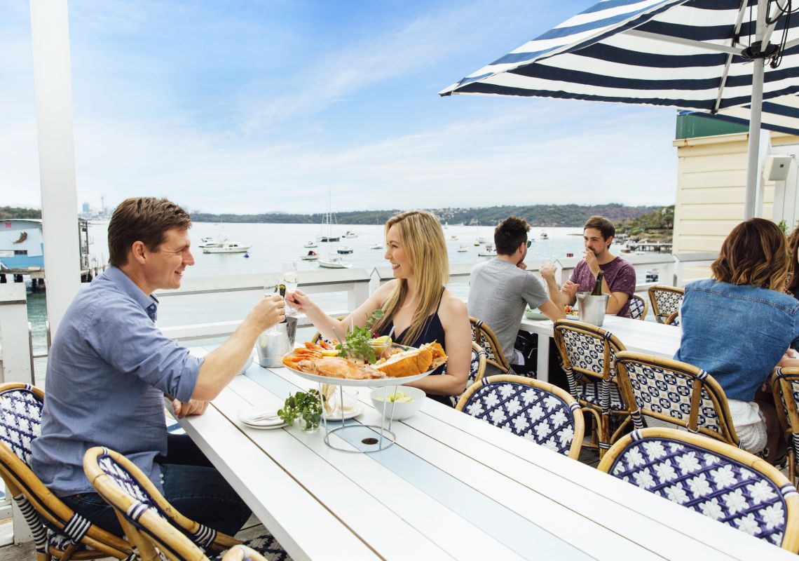 Couple enjoying a seafood platter with waterfront views at Watsons Bay Hotel in Sydney East