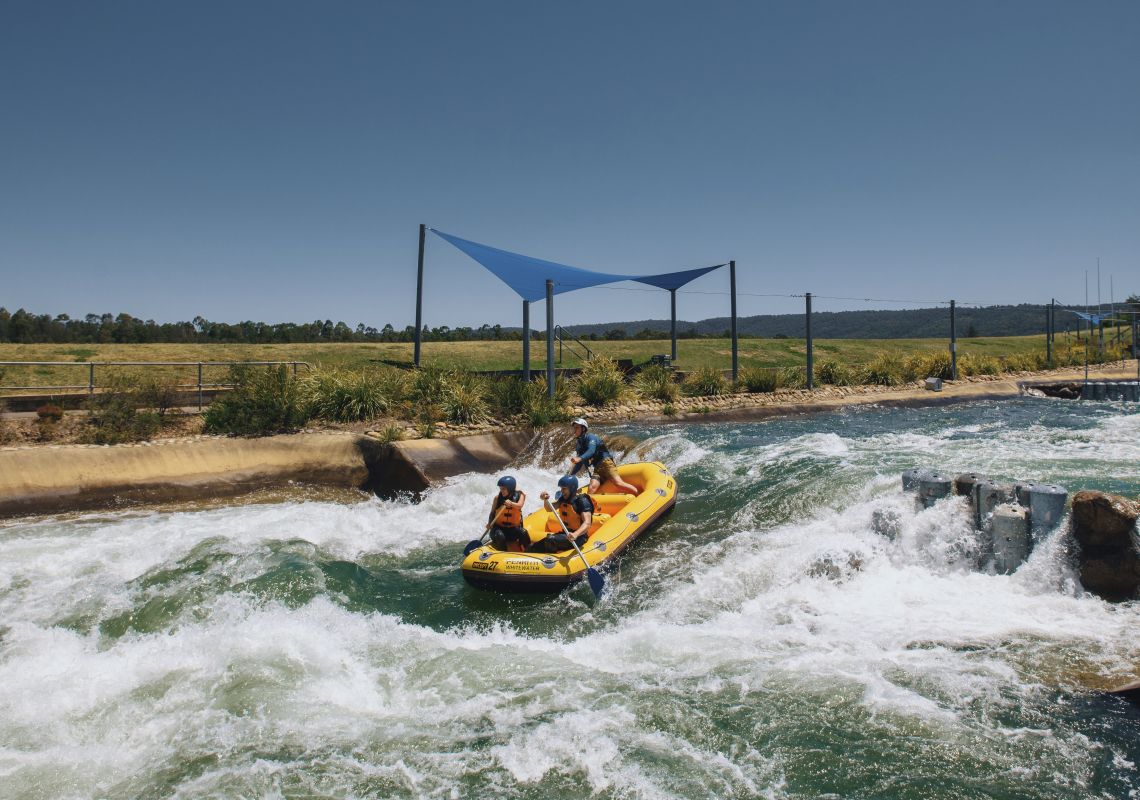 Couple enjoying a white water rafting experience at Penrith Whitewater Stadium in Sydney's west.