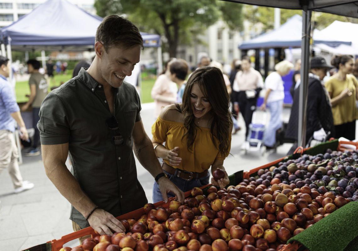 Couple browsing for fresh fruit at the Farmers Market in Centenary Square, Parramatta